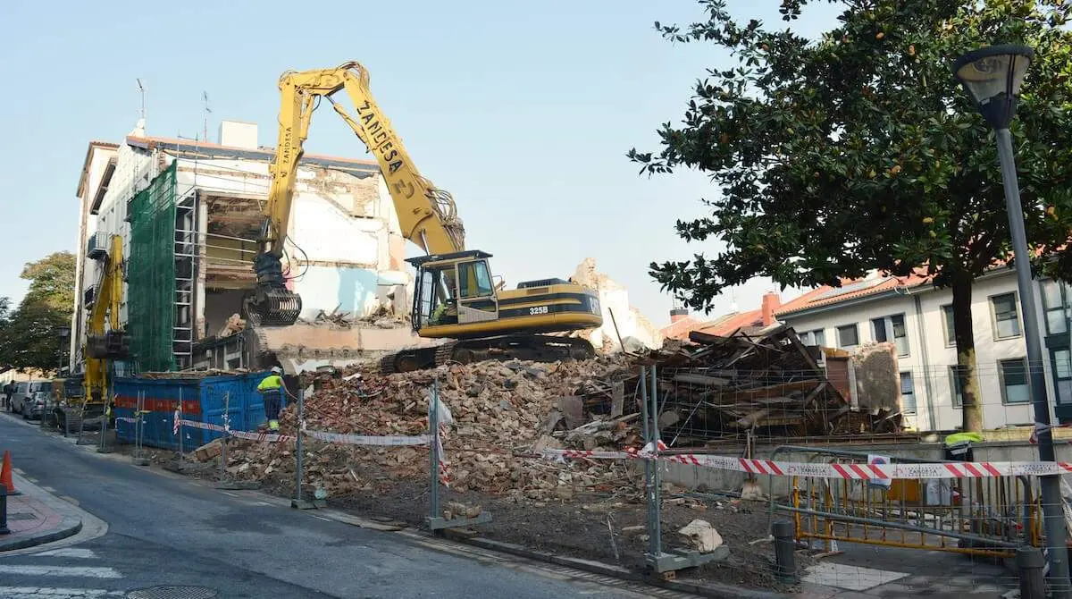 Maquinaria pesada trabajando en el derribo de los portales 49 y 51 de Los Baños