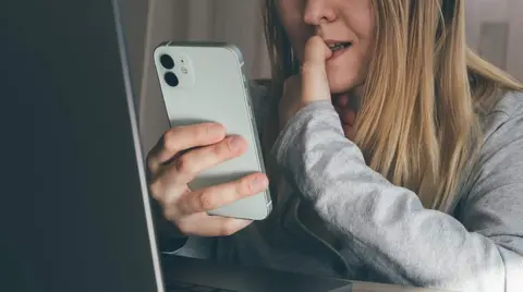 Cropped portrait of female blogger biting fingers nervous using mobile phone. Panic, shock, bullying concept. High quality toned photo about technology and security