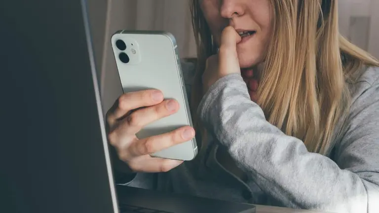 Cropped portrait of female blogger biting fingers nervous using mobile phone. Panic, shock, bullying concept. High quality toned photo about technology and security